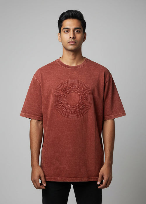 Red t-shirt with a logo on a hanger against a wooden door background
